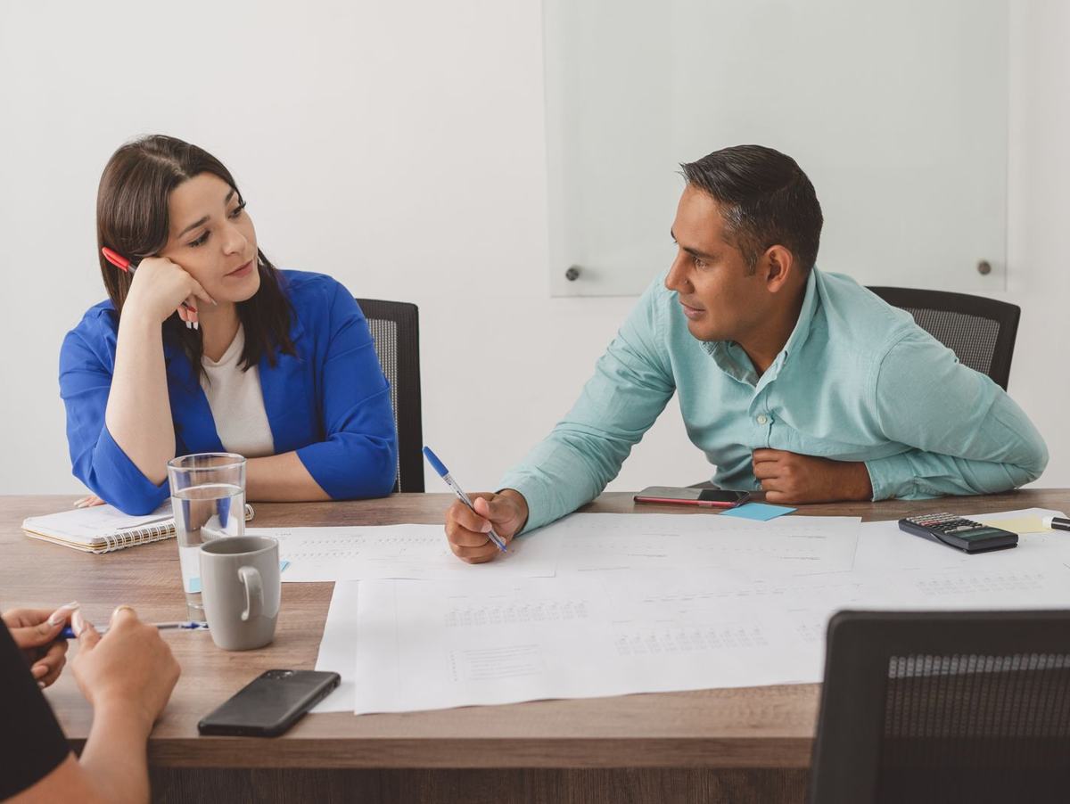 Dos personas revisando un plan de equipo sobre la mesa